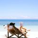 Woman reading book in deckchair on the beach